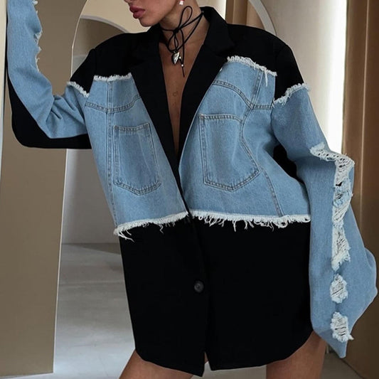 Giacca oversize in denim e tessuto nero con dettagli sfrangiati, indossata da una modella. Moda contemporanea, stile casual-chic.
