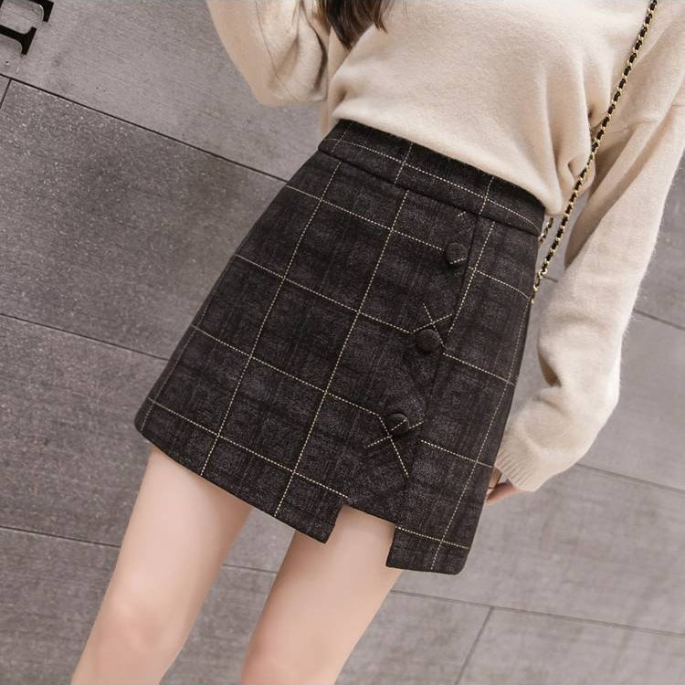 Gonna a quadri marrone con bottoni decorativi, indossata con maglione beige. Moda autunnale, abbigliamento femminile elegante e casual.