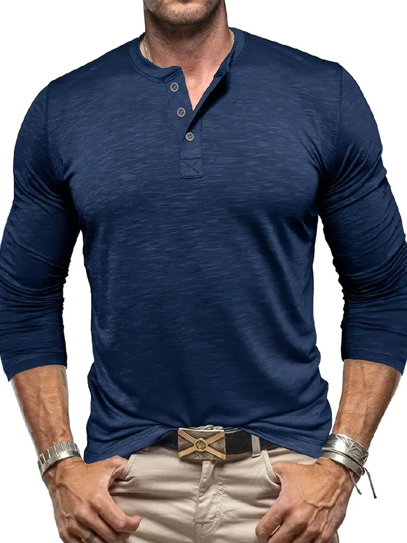 Uomo con maglia Henley blu a maniche lunghe, pantaloni beige e cintura nera. Stile casual maschile, moda uomo, abbigliamento autunnale.