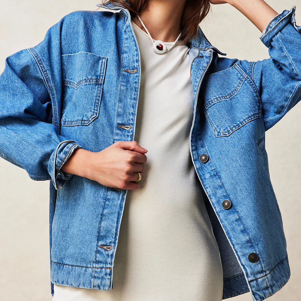 Giacca di jeans blu su sfondo chiaro, indossata sopra un abito bianco. Moda casual, stile denim, abbigliamento femminile trendy.