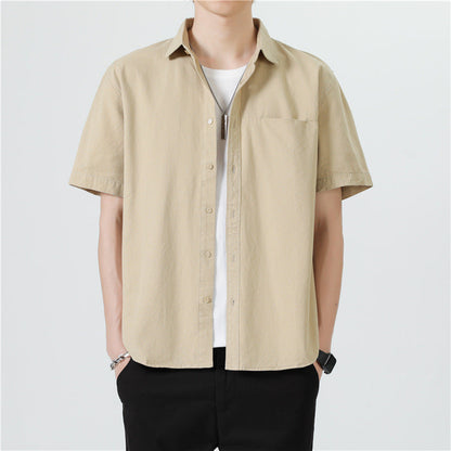 Camicia beige a maniche corte da uomo, stile casual, abbinata a pantaloni neri. Look estivo moderno e minimalista.