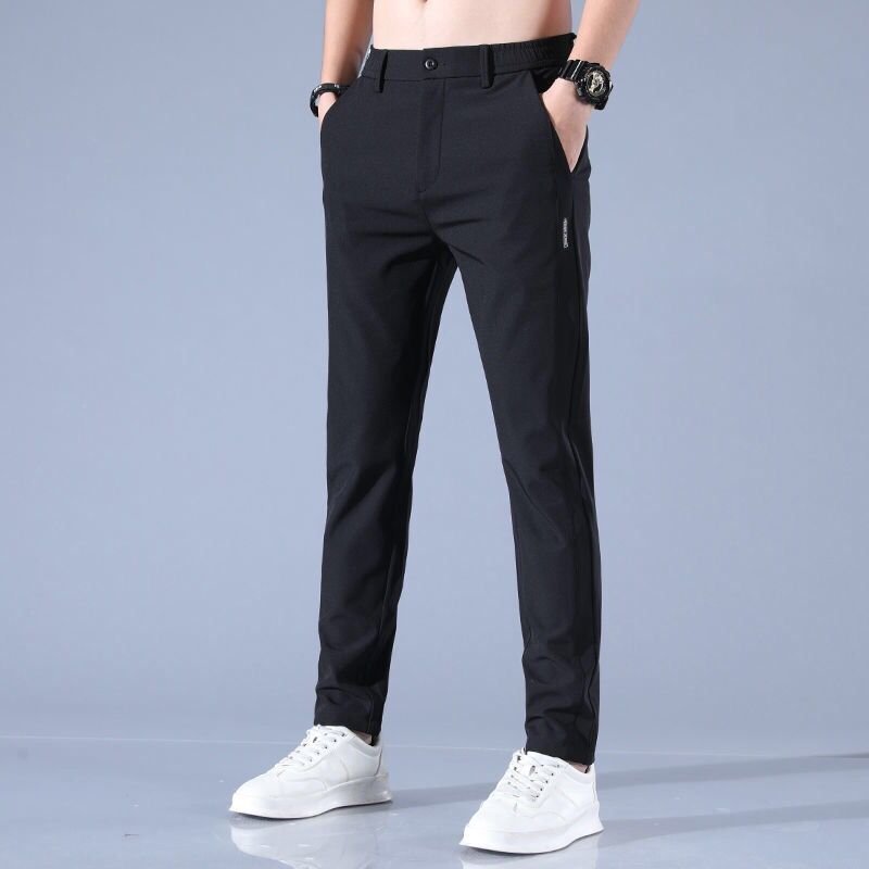 Pantaloni neri eleganti da uomo, vestibilità slim, abbinati a scarpe bianche sportive. Ideali per look casual e formali.
