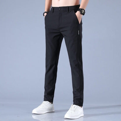 Pantaloni neri eleganti da uomo, vestibilità slim, abbinati a scarpe bianche sportive. Ideali per look casual e formali.