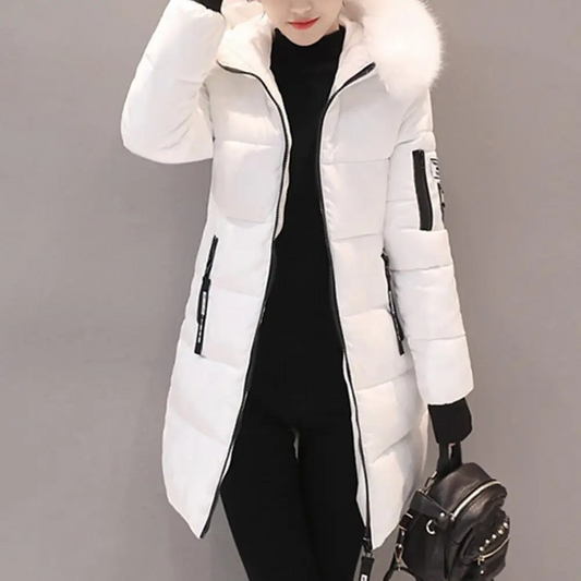 Cappotto invernale bianco da donna con cappuccio in pelliccia sintetica, chiusura a zip, tasche laterali, abbinato a maglione nero e borsa a mano.