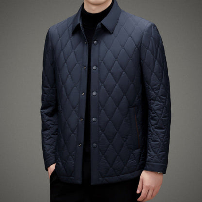 Giacca trapuntata blu scuro da uomo, elegante e moderna, con bottoni frontali e colletto classico. Ideale per moda autunnale e invernale.