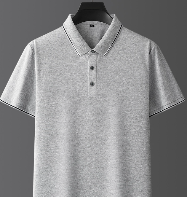 Maglietta polo grigia in cotone, maniche corte, colletto classico, bottoni frontali, design semplice ed elegante, ideale per abbigliamento casual.