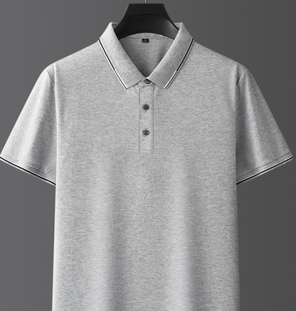 Maglietta polo grigia in cotone, maniche corte, colletto classico, bottoni frontali, design semplice ed elegante, ideale per abbigliamento casual.