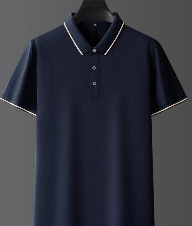 Polo blu scuro da uomo con colletto e bordi bianchi, appesa su gruccia. Elegante e casual, ideale per moda estiva e abbigliamento quotidiano.