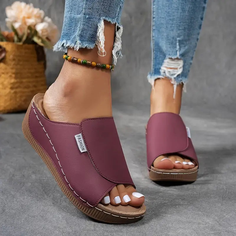 Sandali donna viola con zeppa, indossati con jeans strappati. Design moderno, comodi per l'estate. Accessorio alla caviglia con perline colorate.