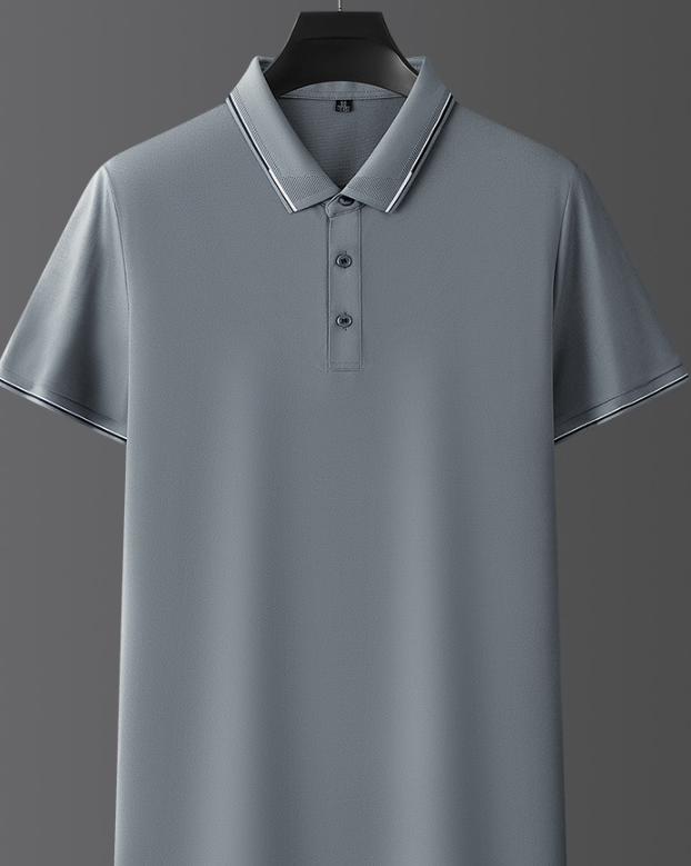 Polo grigia elegante su sfondo grigio, con colletto e bottoni, perfetta per look casual e formali. Maglietta uomo moda 2023.