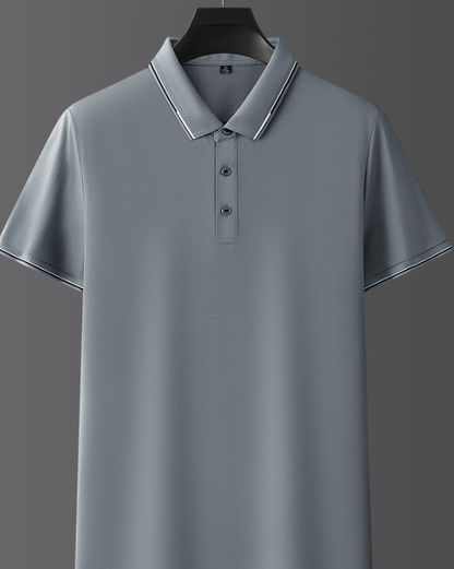 Polo grigia elegante su sfondo grigio, con colletto e bottoni, perfetta per look casual e formali. Maglietta uomo moda 2023.