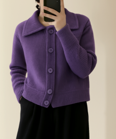Donna in cardigan viola a coste con grandi bottoni, colletto ampio, e pantaloni neri. Moda autunnale, abbigliamento casual elegante.