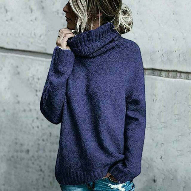 Donna con maglione a collo alto blu, stile casual, sfondo grigio. Moda autunno inverno, abbigliamento caldo e confortevole.