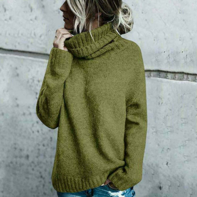 Donna con maglione verde oliva a collo alto, stile casual autunnale, sfondo grigio. Moda femminile, abbigliamento caldo, tendenze 2023.