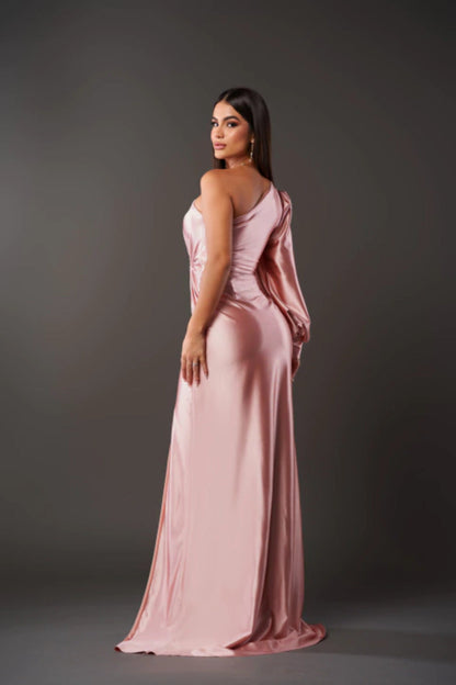 Donna in abito da sera rosa elegante, monospalla, posa su sfondo grigio. Moda femminile, abbigliamento da cerimonia, stile sofisticato.