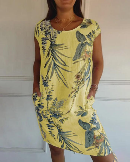 Abito estivo giallo con stampa floreale tropicale, maniche corte, tasche laterali. Moda donna, abbigliamento casual, stile estivo.