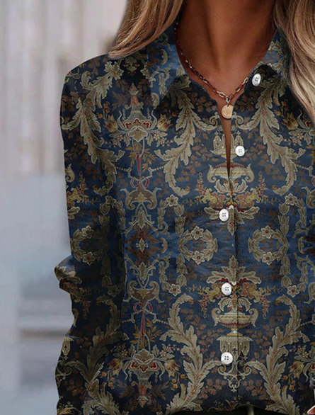 Camicia donna elegante con motivo floreale barocco, sfondo blu e bottoni bianchi. Moda femminile, abbigliamento casual chic, stile autunnale.