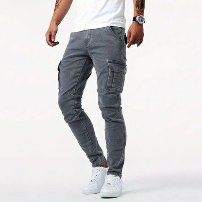 Jeans cargo grigi da uomo, vestibilità slim, con tasche laterali, abbinati a scarpe da ginnastica bianche e t-shirt bianca. Moda casual maschile.