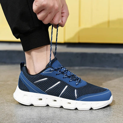 Scarpa da ginnastica blu con suola bianca, design moderno e lacci intrecciati, indossata da una persona su sfondo giallo. Scarpe sportive uomo.