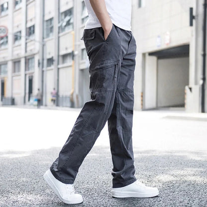 Pantaloni cargo grigi da uomo, stile casual, indossati con scarpe bianche su strada urbana. Moda maschile, abbigliamento comodo, tendenza streetwear.