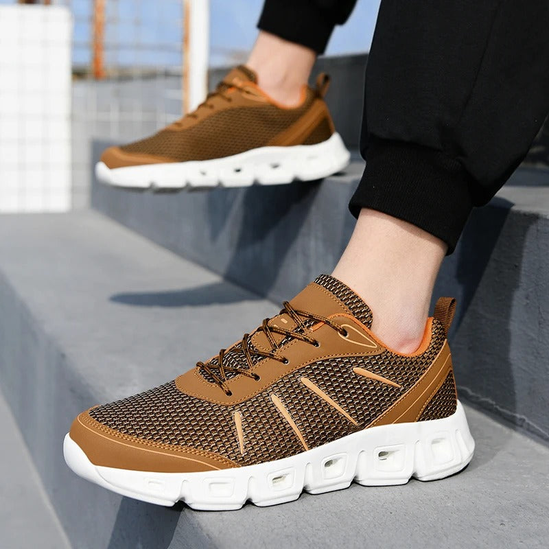 Scarpe da ginnastica marroni su gradini grigi, design moderno e suola bianca ammortizzata. Scarpe sportive uomo, moda casual, comfort urbano.