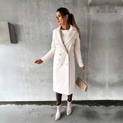 Donna con cappotto bianco elegante, stivali abbinati e borsa beige, posa su sfondo grigio. Moda autunnale, stile chic, abbigliamento invernale.
