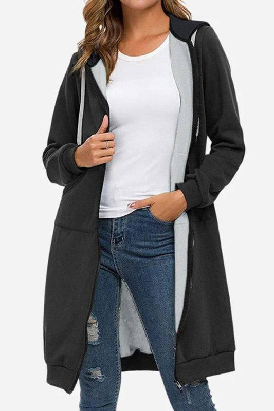Donna con cappotto lungo nero, maglietta bianca e jeans strappati. Moda casual, abbigliamento autunnale, stile urbano.