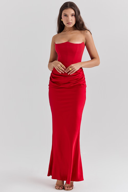 Donna in abito lungo rosso elegante, senza spalline, con drappeggio in vita. Moda femminile, abbigliamento da sera, stile sofisticato.