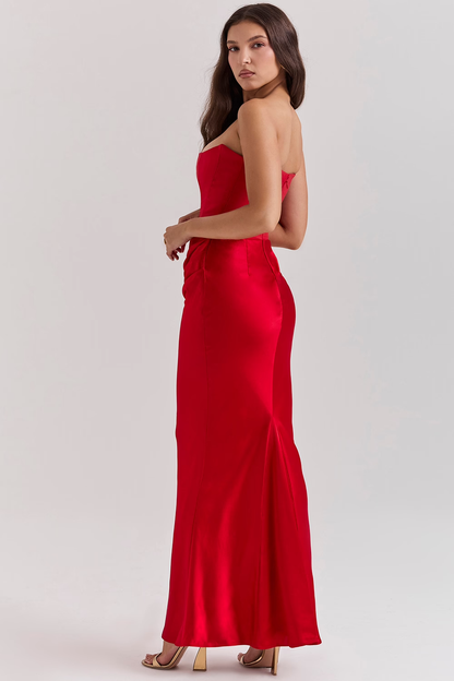 Donna in abito lungo rosso elegante, senza spalline, in posa laterale. Moda femminile, abbigliamento da sera, stile glamour.