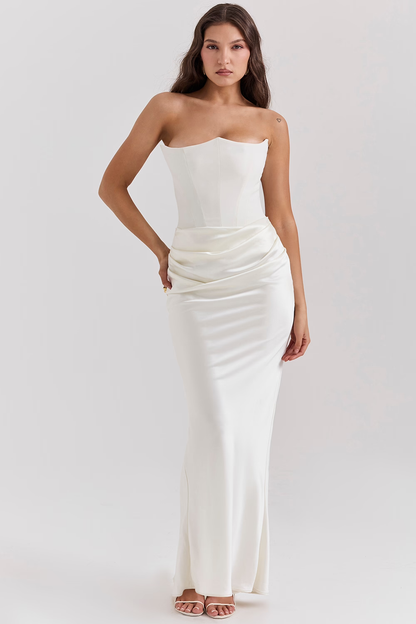 Donna in abito da sera bianco elegante, senza spalline, con drappeggio in vita. Moda femminile, abbigliamento formale, stile sofisticato.