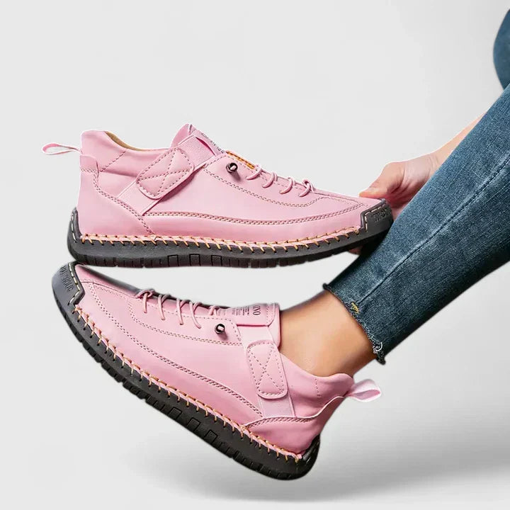 Scarpe da ginnastica rosa per donna, design moderno con suola nera antiscivolo, indossate con jeans. Calzature casual alla moda.