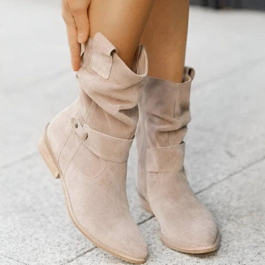 Stivali beige in pelle scamosciata, design casual con fibbia decorativa, indossati su pavimento chiaro. Moda autunnale, calzature eleganti.