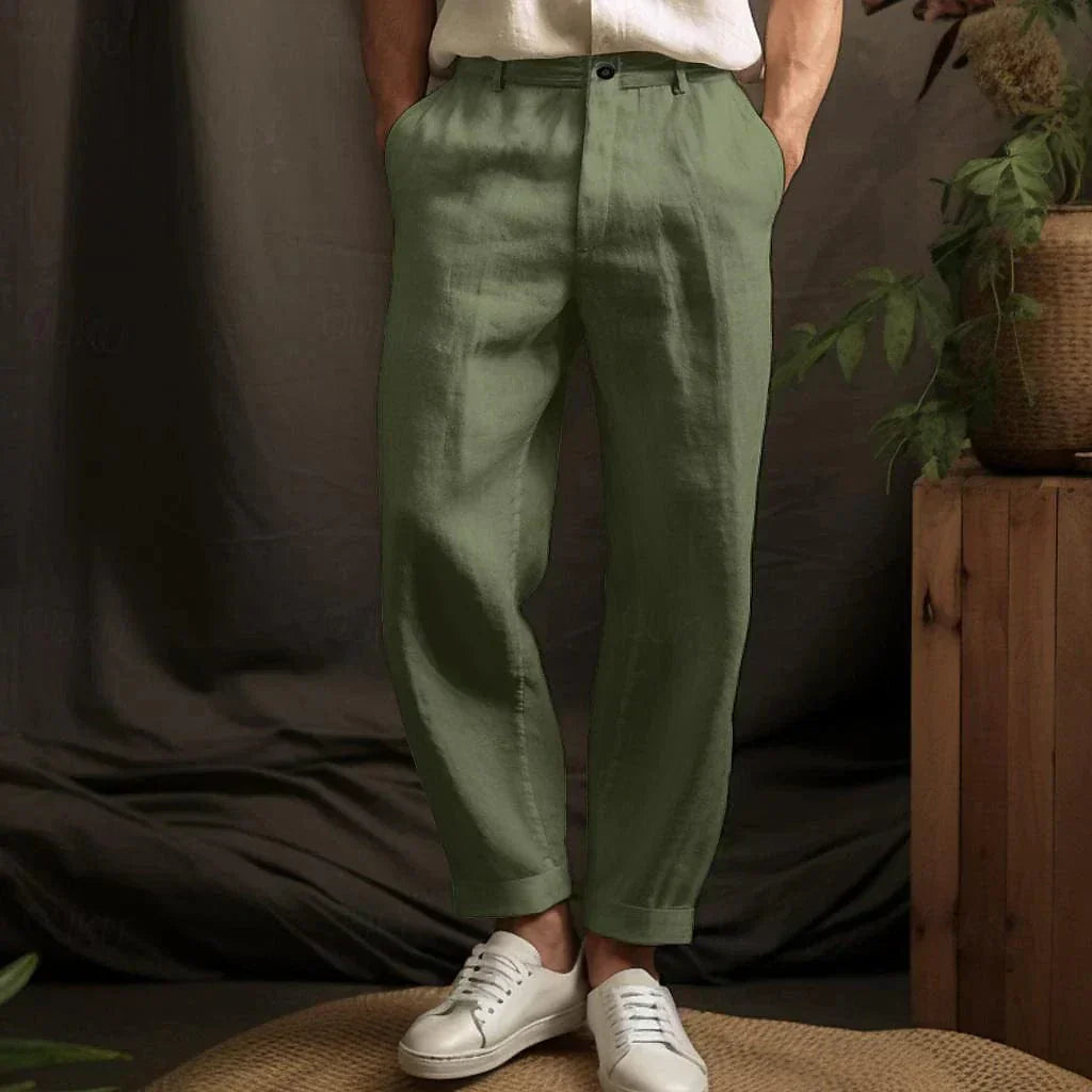 Pantaloni di lino verde da uomo, eleganti e casual, abbinati a scarpe bianche. Moda maschile estiva, stile rilassato e naturale.
