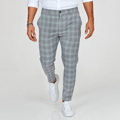Pantaloni uomo a quadri grigi, eleganti e moderni, abbinati a camicia bianca e sneakers bianche. Moda maschile casual chic.