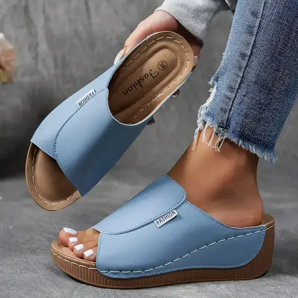 Sandali donna blu chiaro, suola in legno, indossati con jeans strappati. Calzature estive moda, comode e casual.