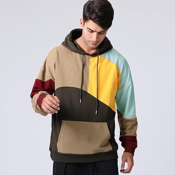 Uomo con felpa multicolore a blocchi, cappuccio e tasca frontale. Moda casual, abbigliamento streetwear, tendenze autunno inverno.