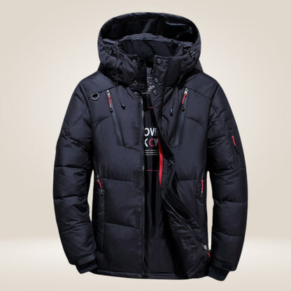 Giacca invernale nera imbottita con cappuccio, cerniera frontale, tasche multiple e dettagli rossi. Ideale per climi freddi e attività all'aperto.
