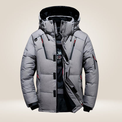 Giacca invernale da uomo grigia con cappuccio, imbottitura calda, chiusura a zip, tasche multiple, design moderno. Ideale per climi freddi.