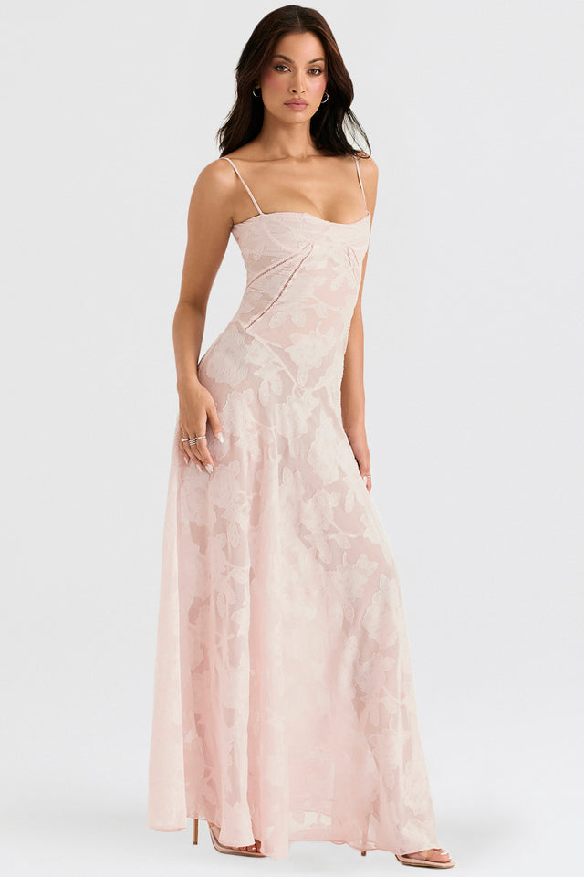 Donna in abito lungo rosa con spalline sottili e motivo floreale, posa elegante. Moda femminile, abbigliamento da sera, tendenze 2023.