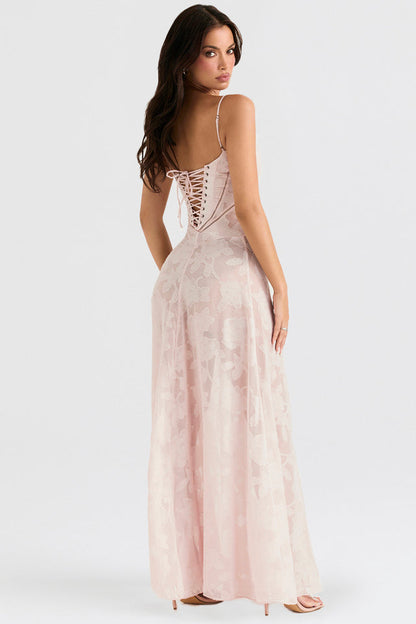 Donna in abito lungo rosa con schiena scoperta e lacci, posa elegante. Vestito da sera, moda femminile, abbigliamento elegante.
