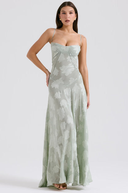 Donna in abito lungo verde chiaro con spalline sottili e motivo floreale, posa elegante. Moda femminile, abbigliamento estivo, tendenze 2023.