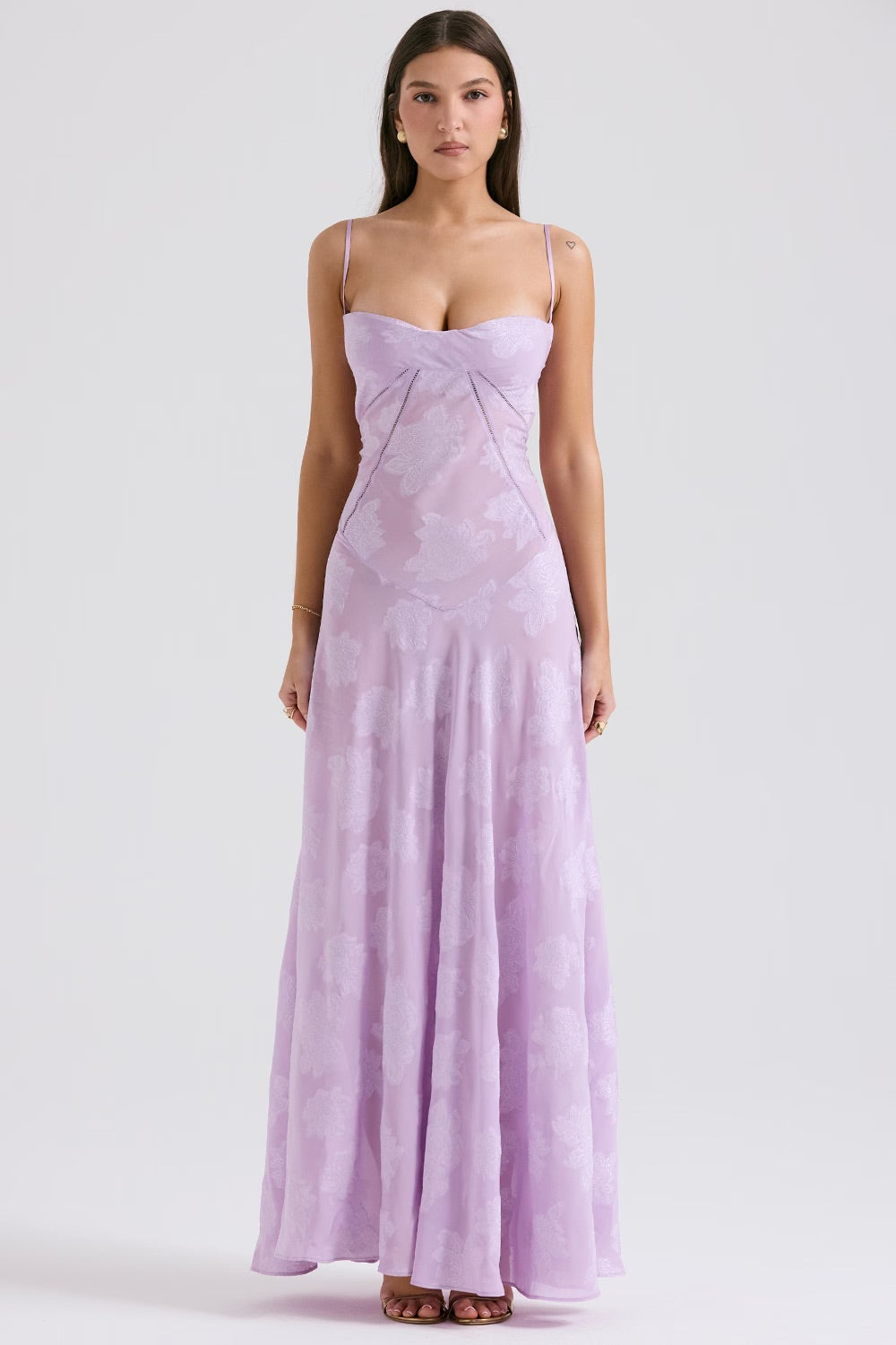 Abito lungo elegante lilla con spalline sottili e motivo floreale, indossato da una donna. Vestito da sera estivo, moda femminile raffinata.