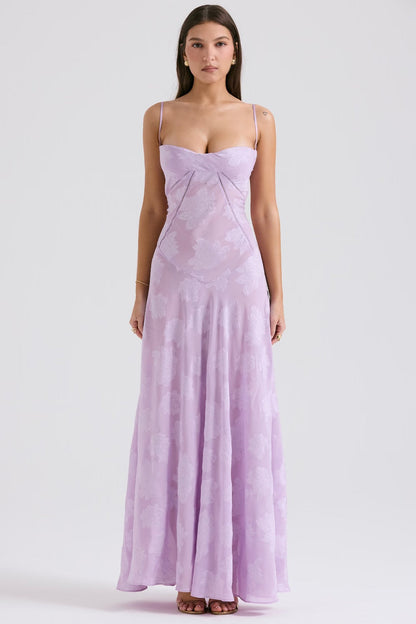 Abito lungo elegante lilla con spalline sottili e motivo floreale, indossato da una donna. Vestito da sera estivo, moda femminile raffinata.