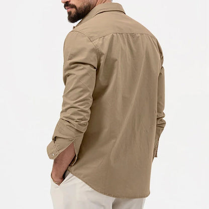 Camicia beige da uomo vista posteriore, maniche lunghe, stile casual, tessuto leggero, abbinata a pantaloni chiari. Moda maschile elegante.