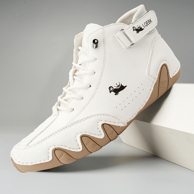 Scarpa da basket bianca con suola in gomma beige, design moderno, logo stilizzato, chiusura a strappo, ideale per sport e moda urbana.