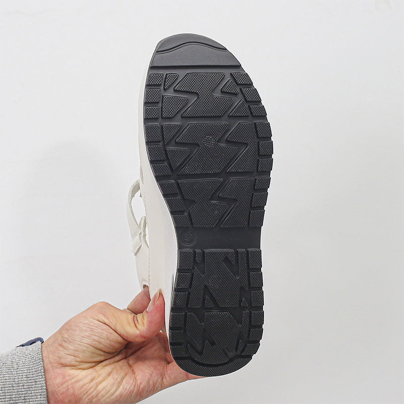 Suola di scarpa in gomma nera con motivo antiscivolo, tenuta in mano. Design robusto, ideale per calzature da lavoro o outdoor.