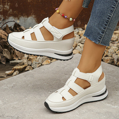 Scarpe da donna bianche con zeppa, design a sandalo, chiusura a strappo, indossate con jeans. Calzature estive eleganti e comode.