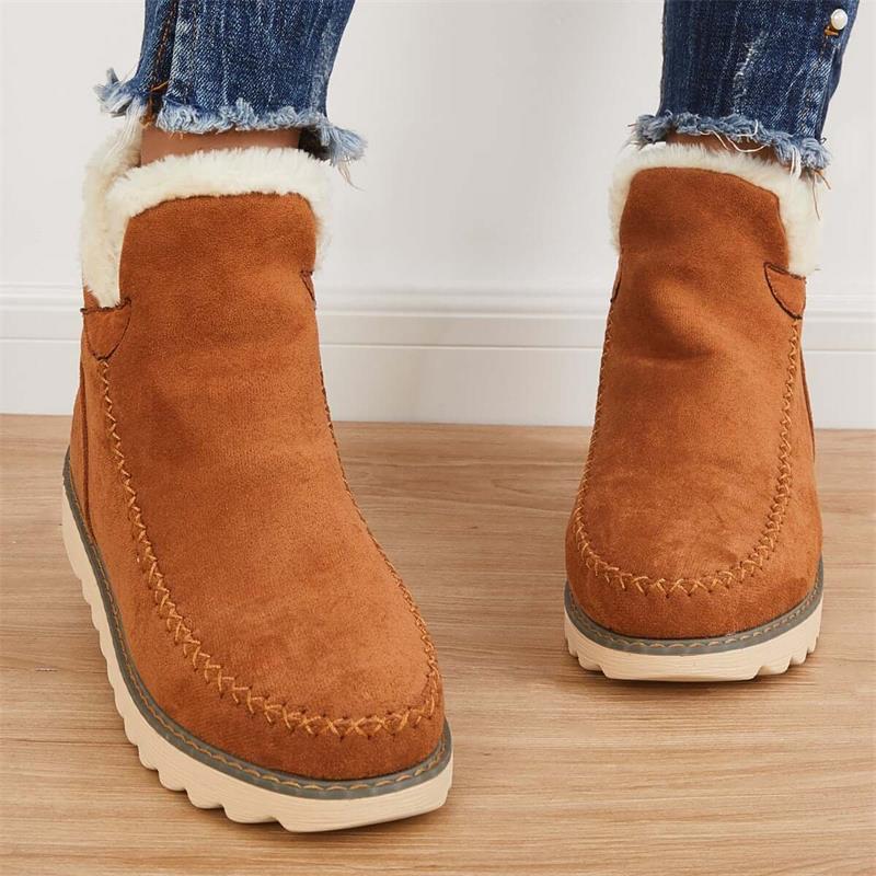 Stivaletti invernali marroni in pelle scamosciata con fodera in pelliccia sintetica, suola antiscivolo, indossati con jeans strappati.