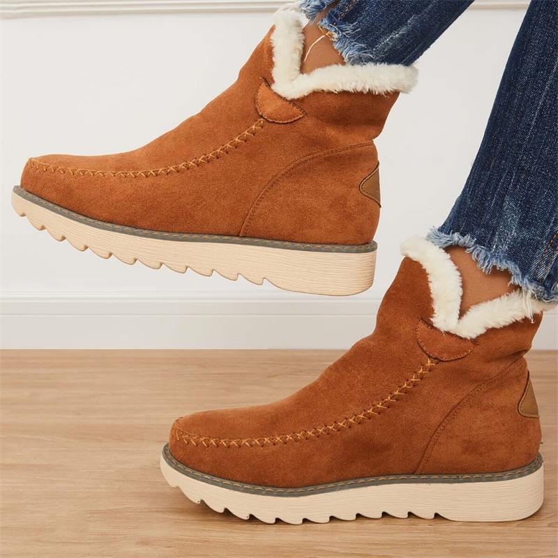 Stivaletti invernali marroni in pelle scamosciata con fodera in pelliccia sintetica, suola in gomma antiscivolo, indossati con jeans.