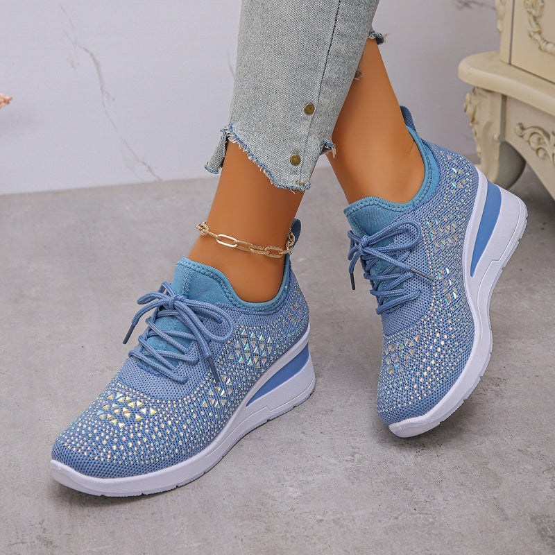 Scarpe da ginnastica blu con dettagli brillanti, suola bianca, indossate con jeans chiari. Scarpe sportive eleganti per donna, moda casual.